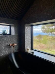 Frittstående matt svart badekar ved panoramavindu med naturutsikt over Malvik – eksklusiv baderomsrenovering Naustmarka